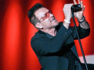 Pavel Sfera singing on stage as Bono