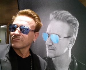 Pavel Sfera posing next to a portrait of Bono