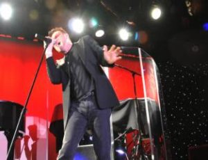 Pavel Sfera singing on stage as Bono